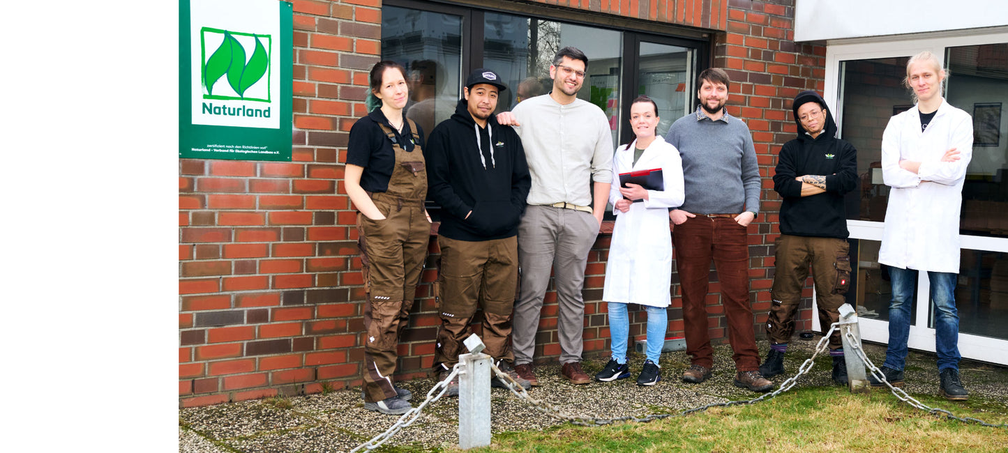 Foto des 7-köpfigen EntoSus-Teams vor dem Gebäude, in dem sich die Grillenfarm befindet.